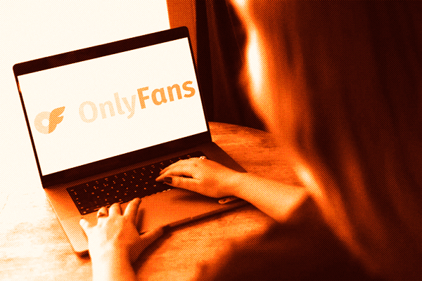 woman seen from behind with a laptop open to onlyfans logo